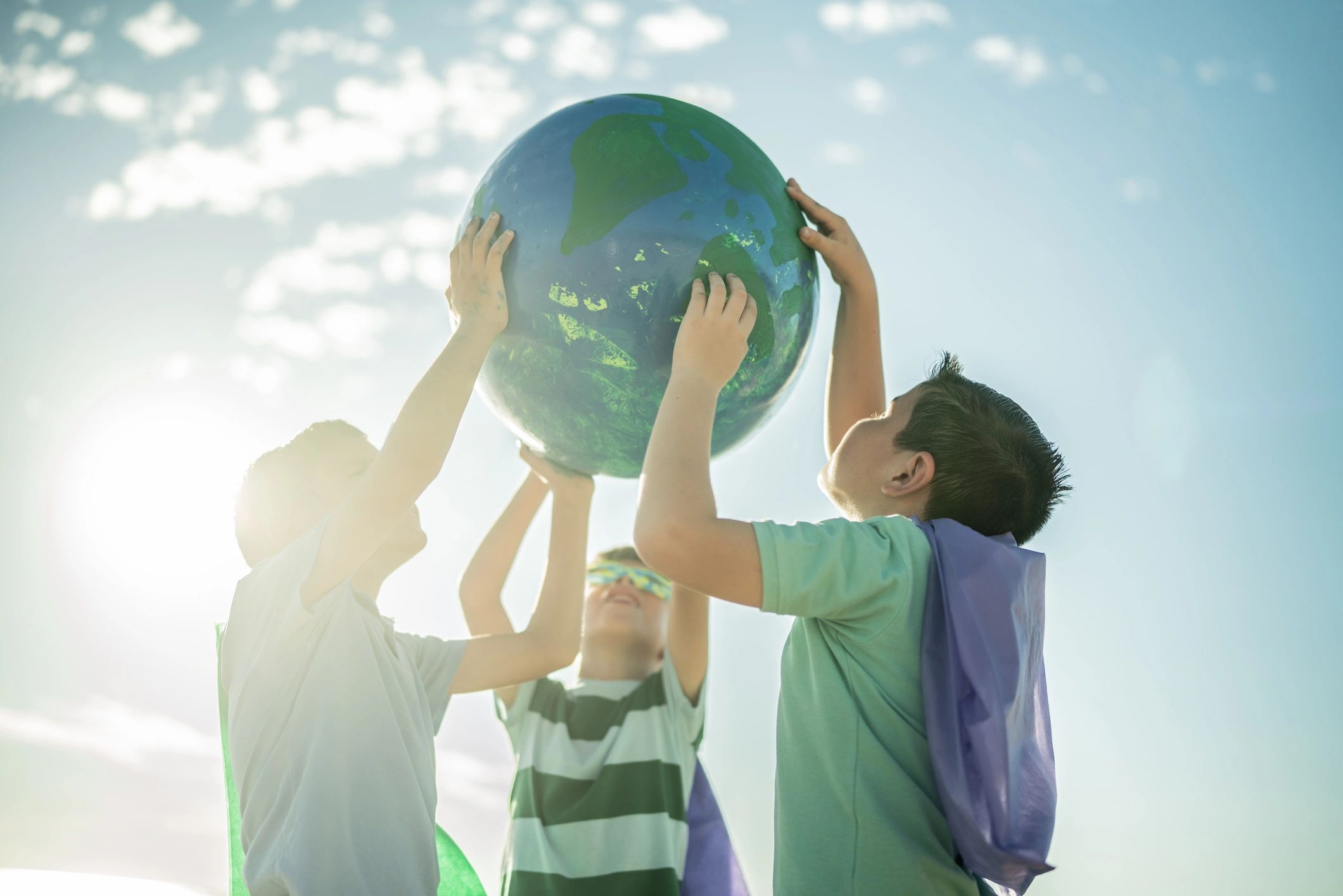 Children holding a globe together