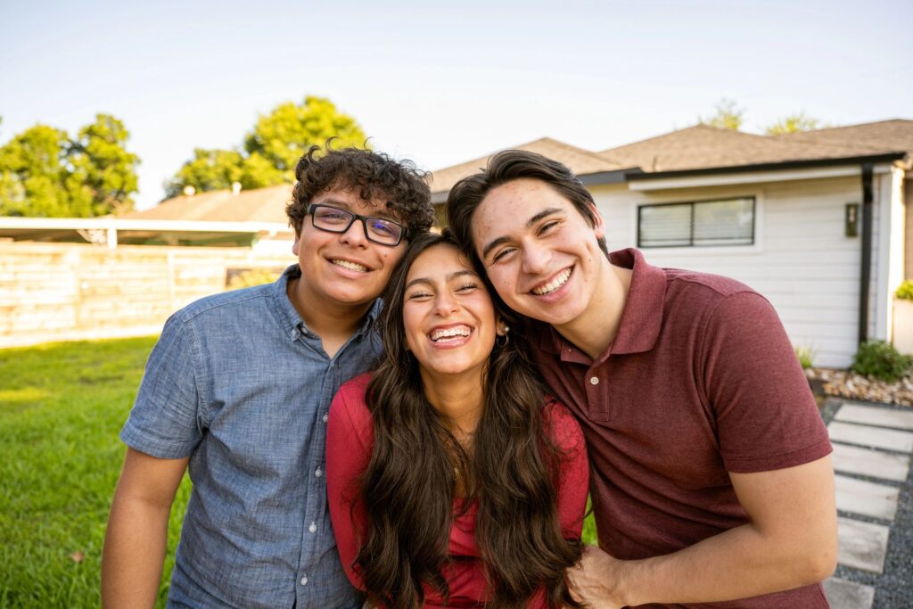 Portrait of three gen z siblings laughing